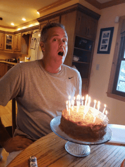 Man In Nike Shirt Sitting At Cake Table GIF