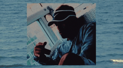 Man In Nike Visor Sitting By Water GIF