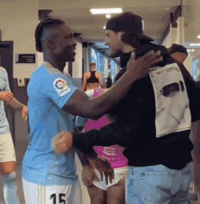 Man In Number 15 Jersey Hugging Man In Black Shirt GIF