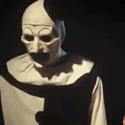 Man In Nun Costume Holding Paper In Dark GIF