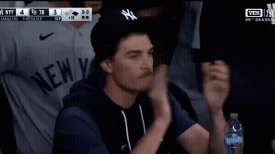 Man in NY Hat and Blue Shirt With Aquafina Water