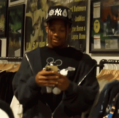 Man In NY Hat Looking At Cell Phone GIF