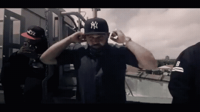 Man In NY Hat Next To Man In Black Shirt With Letter B GIF