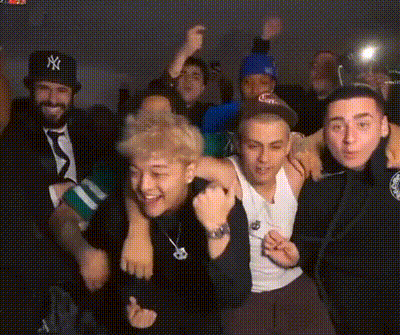 Man In NY Hat Surrounded By Men GIF