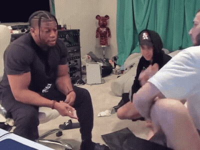 Man In NY Hoodie Sitting With Others GIF