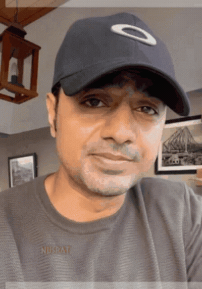 Man in Oakley Hat and Nusrat Shirt Smiling