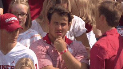 Man In Oklahoma Hat Sits In Crowd GIF