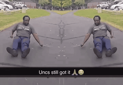 Man In Oklahoma Shirt Sliding Down Road GIF