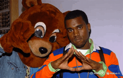 Man In Orange And Blue Sweater Next To Teddy Bear GIF