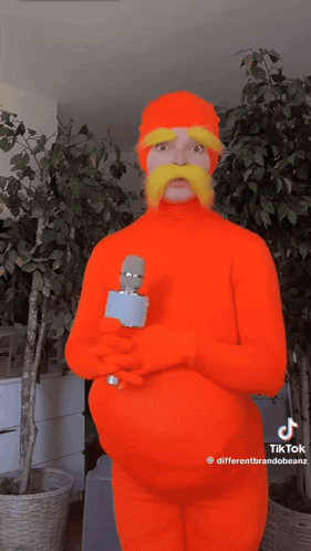 Man In Orange Costume Holding Microphone GIF