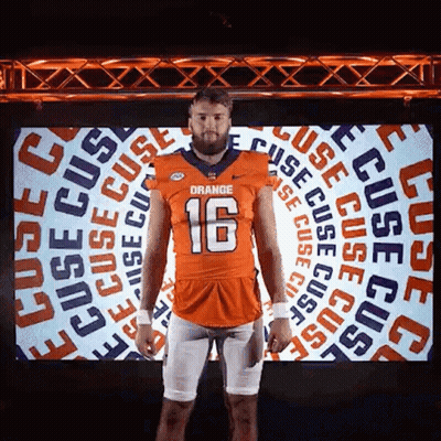 Man In Orange Football Jersey Standing In Front Of Screen GIF