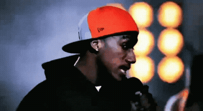 Man In Orange Hat With Letter F At Microphone GIF