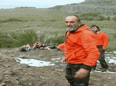 Man In Orange Jacket On Hillside GIF
