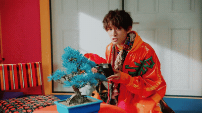 Man In Orange Jacket Photographing Blue Tree GIF
