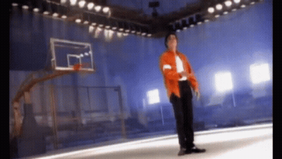 Man In Orange Jacket Standing In Front Of Basketball Hoop GIF