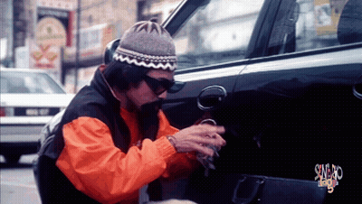 Man In Orange Jacket Working On Car With Swag Sign GIF