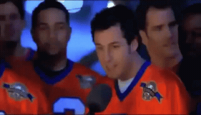 Man In Orange Jersey Talking Into Microphone With Men GIF