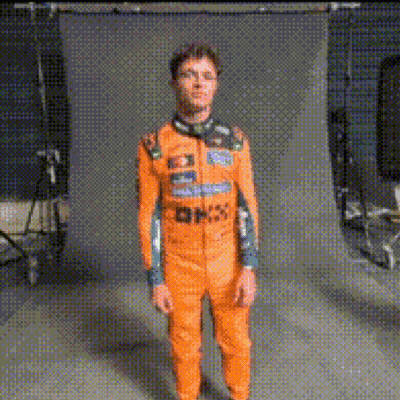 Man In Orange Jumpsuit Standing In Front Of Wall GIF