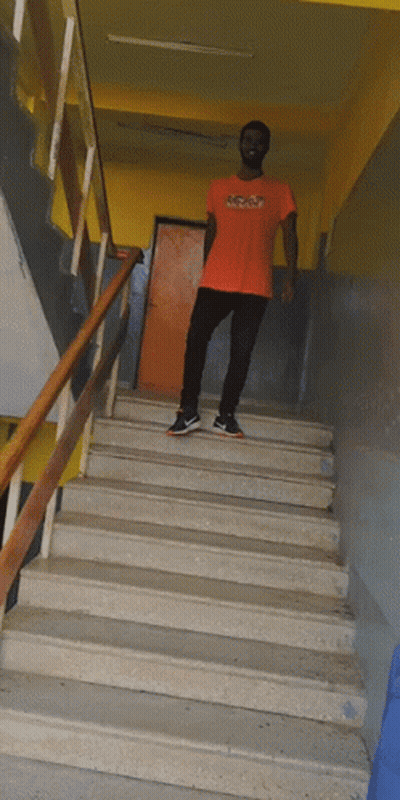 Man In Orange NC State T-Shirt On Stairs GIF