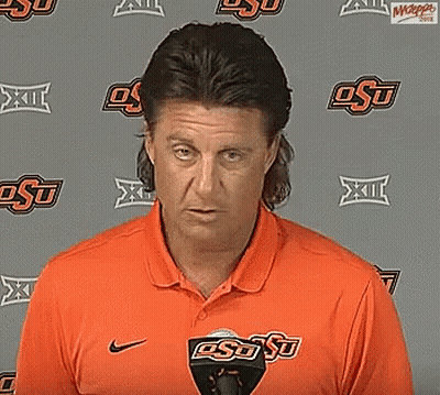Man In Orange OSU Shirt Standing In Front Of Wall GIF