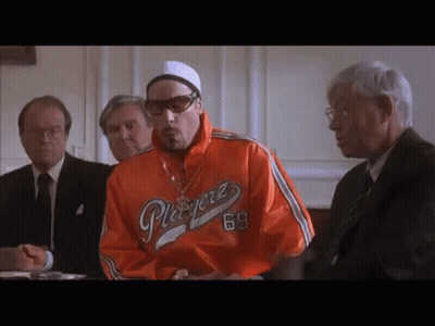 Man In Orange Playerz 69 Jacket At Table With Men GIF