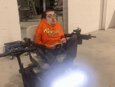 Man In Orange Reese's Hoodie Sitting GIF