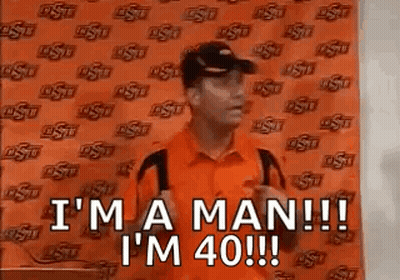 Man In Orange Shirt And Black Hat Saying I'm A Man GIF