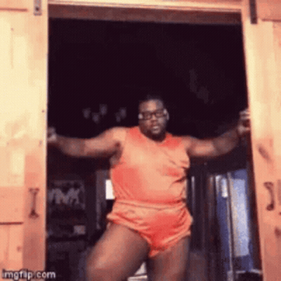Man in Orange Shirt Dancing in Doorway