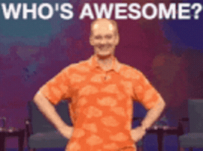 Man In Orange Shirt Hands On Hips Says Who's Awesome GIF