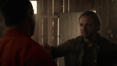 Man In Orange Shirt Hugging Man In Grey Shirt GIF