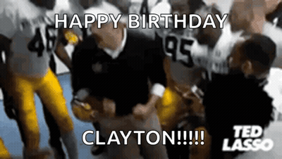 Man In Orange Shirt Making Funny Face In Front Of Trophies GIF