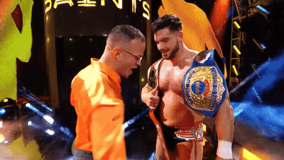 Man In Orange Shirt Next To Wrestler GIF