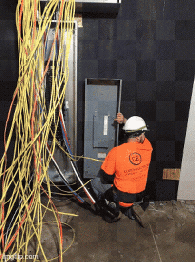Man In Orange Shirt Saying CE Working On Electrical Panel GIF