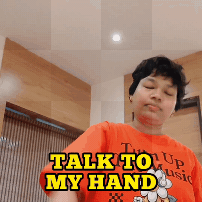 Man In Orange Shirt Saying Talk To My Hand GIF