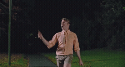 Man In Orange Shirt Stretching Arms GIF