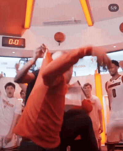 Man In Orange Shirt Throwing Basketball In Front Of Clock Saying 0-0 GIF