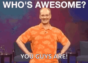 Man In Orange Shirt With Hands On Hips Says Who's Awesome GIF