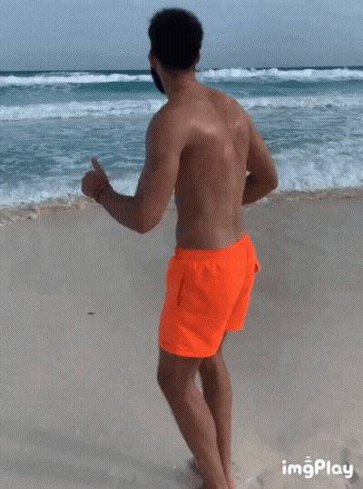 Man In Orange Shorts Running Beach GIF