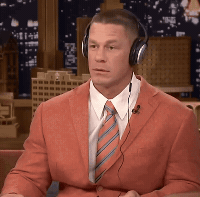 Man In Orange Suit And Headphones Looking At Camera GIF