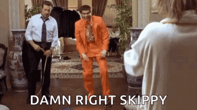 Man In Orange Suit Dancing In Front Of Woman GIF
