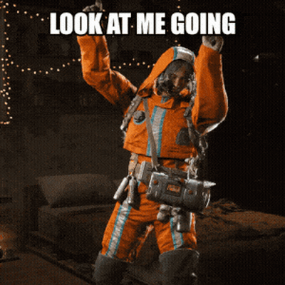 Man In Orange Suit Holding Gun Saying Look At Me Going GIF