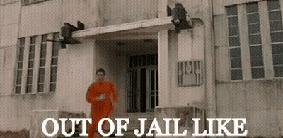 Man In Orange Suit Running In Front Of Out Of Jail Building GIF
