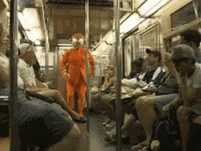 Man in Orange Suit Standing in Train