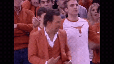 Man In Orange Suit With Longhorn Among Crowd GIF