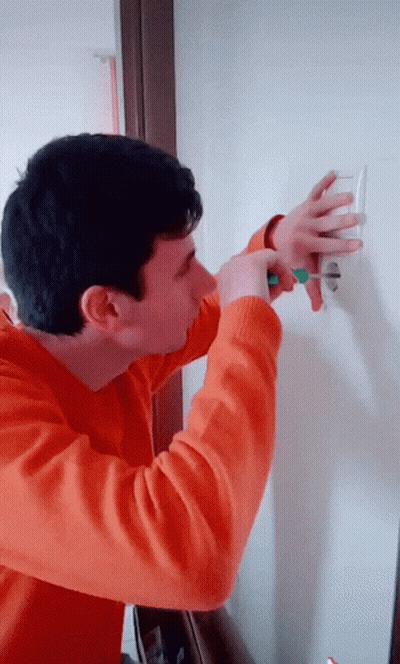 Man In Orange Sweater Holding Green Screwdriver GIF