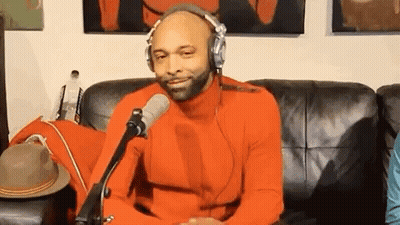 Man In Orange Sweater Wearing Headphones GIF