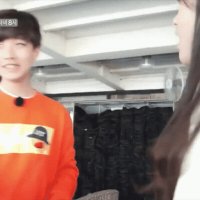 Man In Orange Sweatshirt Talking To Woman GIF