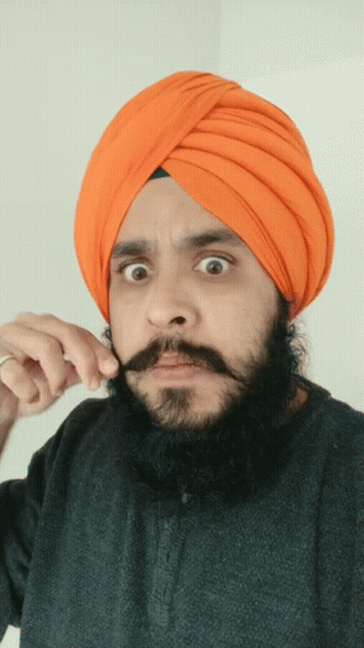 Man In Orange Turban And Black Shirt Holding Mustache GIF