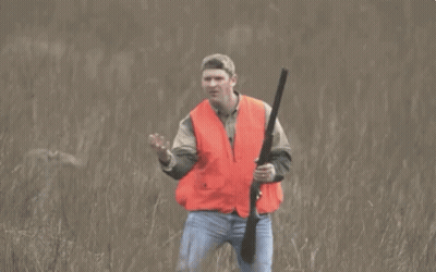 Man In Orange Vest Holding Gun GIF