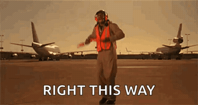 Man In Orange Vest On Runway Says Right This Way GIF